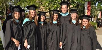 Graduate students on campus in their caps and gowns for commencement